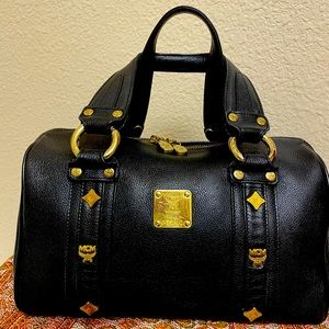 Black MCM gold hardware and studded leather bag.